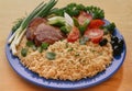 Vermicelli, noodles with beef steak on a blue plate, decorated with sliced tomatoes, black olives Royalty Free Stock Photo